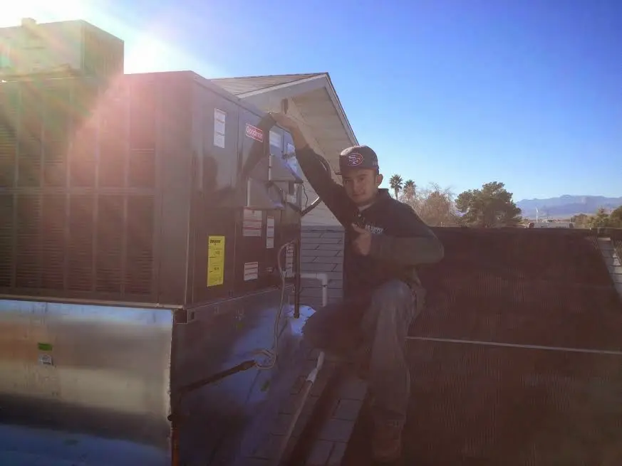 HVAC technician performing Heat Pump Repair on a rooftop unit in Ramona
